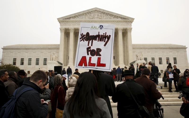 A demonstrator holds a sign aloft as the affirmative action in university admissions case was being heard at the Supreme Court in Washington, December 9, 2015. REUTERS/Kevin Lamarque